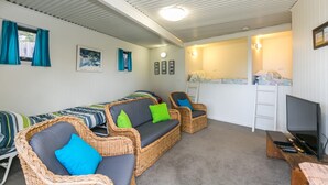 Et værelse med en sofa, et fjernsyn og et lille bord.