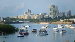 Un port de plaisance où sont amarrés de nombreux bateaux, entouré d’une vue urbaine avec des gratte-ciel.