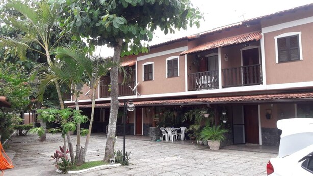 A two-story building with a balcony, outdoor seating area, and potted plants. - EXCELLENT DUPLEX HOUSE NEARBY PERÓ AND CONCHAS BEACH!!! (Peró)