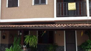 A two-story house with a balcony, potted plants, and a tiled roof. - EXCELLENT DUPLEX HOUSE NEARBY PERÓ AND CONCHAS BEACH!!! (Peró)