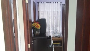 A hallway with a black cabinet and a small table with a vase of flowers. - EXCELLENT DUPLEX HOUSE NEARBY PERÓ AND CONCHAS BEACH!!! (Peró)