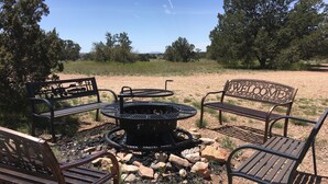 A fire pit surrounded by metal benches in an outdoor setting. - Popular Vacation Rental At The Grand Canyon, Make yourselves at Home! (Williams)