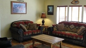 A living room with two sofas, a coffee table, and a lamp. - Popular Vacation Rental At The Grand Canyon, Make yourselves at Home! (Williams)