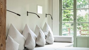 Ein Zimmer mit großem Fenster, weißer Wand und Holzbalken.