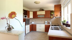 Una cocina con armarios de madera, un microondas, una estufa y un lavabo.