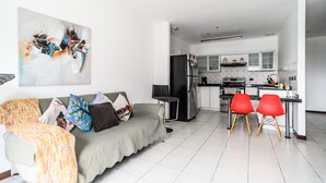 Ein modernes Wohnzimmer mit einer Couch, einem Couchtisch und einem Gemälde an der Wand.