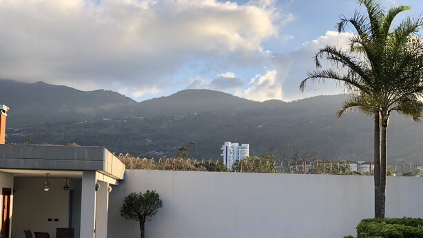 Eine moderne Außenpatio mit Pool, Essbereich und Bergblick.