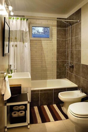 A modern bathroom with a bathtub, a bidet, a toilet, and a small window. - Best Block in Palermo Hollywood (Capital Federal)