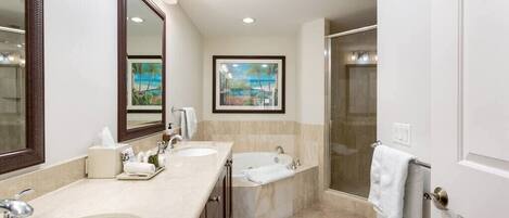 A modern bathroom with two sinks, a bathtub, a shower, and a large mirror.