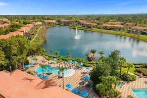 A resort with a large lake, multiple swimming pools, and a well-maintained landscape.