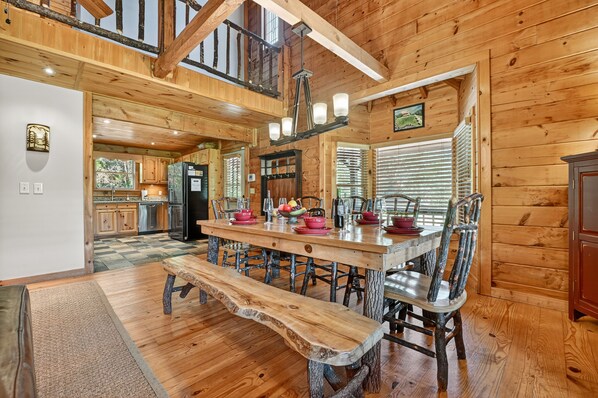 A rustic wooden interior with a large dining table, benches, and a chandelier. - Meadow Creek - Pet-friendly retreat with rambling creek, hot tub, fire-pit, WiFi, and sprawling manicured meadow land for serene relaxation (Morganton)