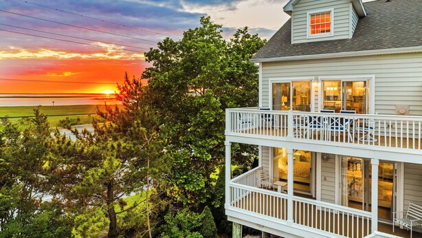 A two-story house with a balcony overlooking a scenic view. - Rare private beach side location that also has beautiful bayside views (Bethany Beach)