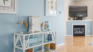 A living room with a white console table, a fireplace, and a flat-screen TV mounted above it. - Rare private beach side location that also has beautiful bayside views (Bethany Beach)
