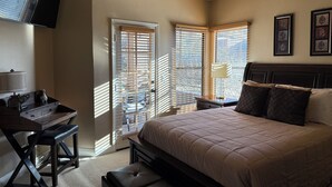 Un dormitorio con cama, escritorio, silla y ventilador de techo.