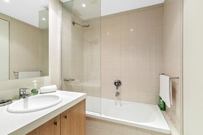 A modern bathroom with a bathtub, a sink, and a shower.