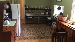 A compact kitchen with a refrigerator, stove, and wooden counter. - The Grove Gunbower.. (Gunbower)