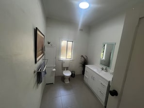 A compact bathroom with a toilet, sink, and a small window. - The Grove Gunbower.. (Gunbower)