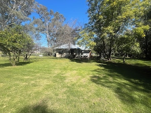 A grassy area with a small building, trees, and a clear sky. - The Grove Gunbower.. (Gunbower)