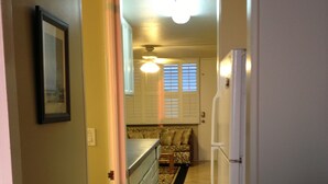 A kitchen with a refrigerator, a dining table, and a window with blinds.