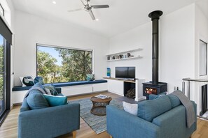 A modern living room with a fireplace, seating area, and a television.