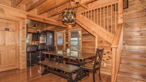 A wooden interior with a dining area, kitchen, and staircase. - 🏔️ A Starr Peak View🌲 Resort Pool, Hot Tub & Game Room (Sevierville)