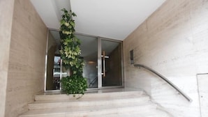 Eine Treppe mit einem Blumentopf, einer Glastür und einem Metallgeländer.
