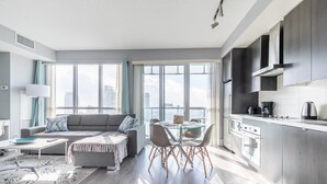 A modern apartment with a living room, dining area, and kitchen. - Modern Downtown Apartments (Toronto)