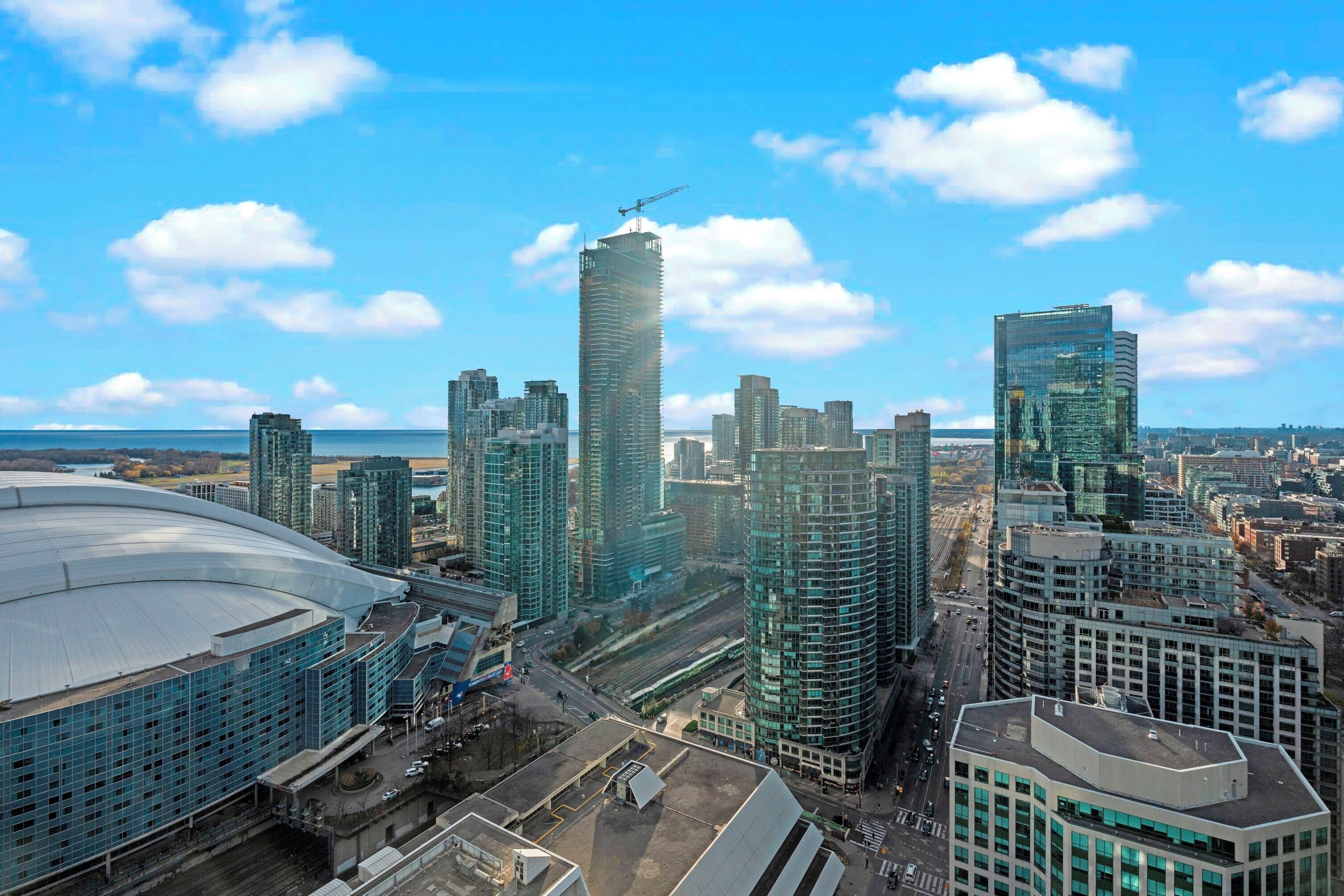 Une vue urbaine avec des immeubles de grande hauteur, un stade et une grue de construction.