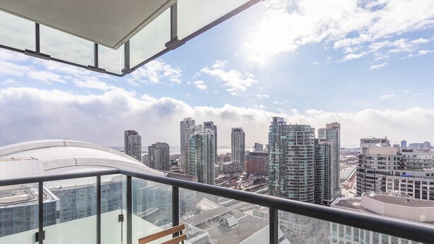 A high-rise building with a glass balcony, offering a city view. - Modern Downtown Apartments (Toronto)
