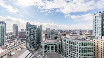 A high-rise urban area with modern buildings, a train track, and a clear sky.