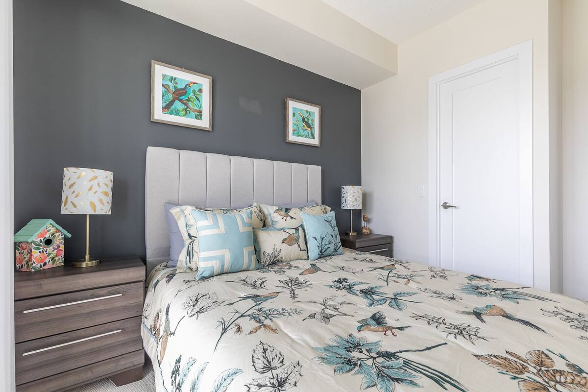 A bedroom with a bed, two nightstands, a dresser, and two framed pictures on the wall.