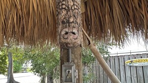 A tiki bar with a wooden post, a thatched roof, and a signboard. - Enjoy a Fun in the Sun getaway 3 Bedroom House, Tiki Hut, Boat Ramp, & Dockage! (Key Largo)