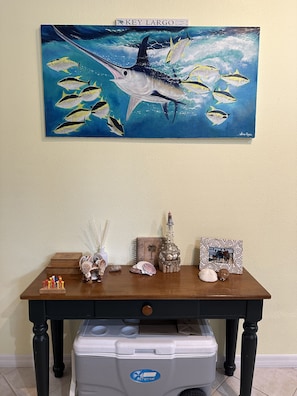 Artwork and decorative pieces adorn the walls and table in this stylish room.