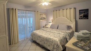 A bedroom with a bed, curtains, a ceiling fan, a radiator, and a window with a view. - Enjoy a Fun in the Sun getaway 3 Bedroom House, Tiki Hut, Boat Ramp, & Dockage! (Key Largo)