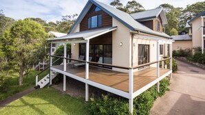 A modern two-story house with a wooden deck and a covered outdoor area. - Yabbarra Sands - Enjoy the beachside lifestyle- Close to Surf, MBT and Whales! (Dalmeny)