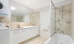 Tina con regadera, tina de hidromasaje, secadora de cabello, toallas 