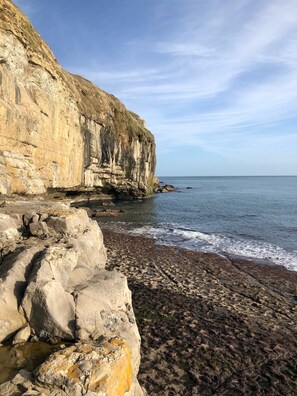 A coastal landscape with a rocky cliff and a beach. - Large Traditional Stone 3 Bedroom 1ST Floor Apartment On The Jurassic Coast. (Langton Matravers)