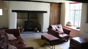 Un salón acogedor con sofás de cuero, chimenea y ventana con vistas.