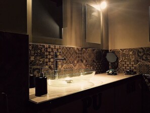 A bathroom with a large sink, a mirror, and patterned tiles on the wall. - Beautifull loft in the hearth of Rome - A wonderful loft in the heart of Rome. (Roma)