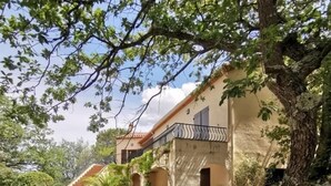 A house with a stone staircase leading to a covered porch, surrounded by trees and gravel. - Stylish villa, 13m private pool, tranquil garden, close to village amenities (Maureillas)