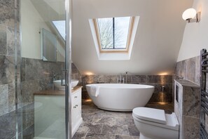 Bathtub, hair dryer, towels, toilet paper