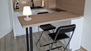 Une petite cuisine équipée comprenant un four à micro-ondes, un évier et une petite table avec deux chaises.