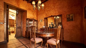 A dining area with a round table, chairs, a chandelier, and a wooden cabinet. - Old school from (Old School from) 1840 Wifi (Fasnia)