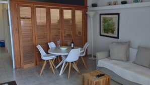 Un salon avec un canapé, une table à manger et des chaises, ainsi qu’une cloison en bois.