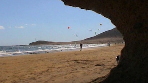 Une plage avec une falaise rocheuse qui la surplombe.