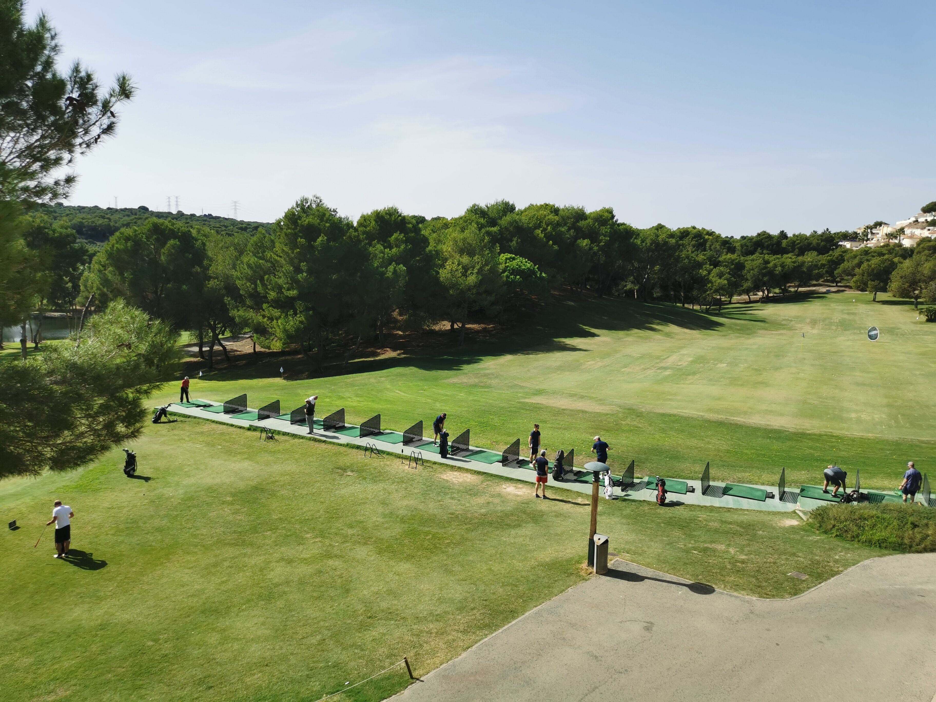 A golf course with a clear path, green fairways, and trees in the background.
