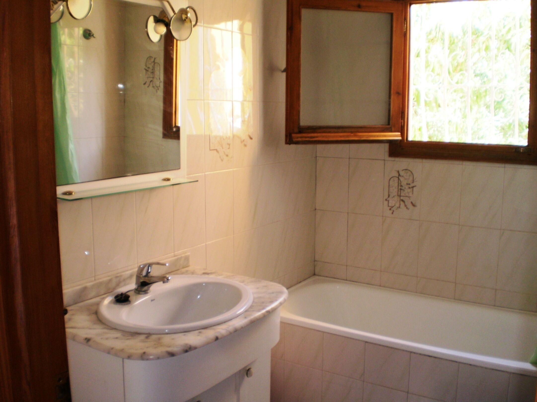 A bathroom with a white sink, a mirror, and a bathtub.