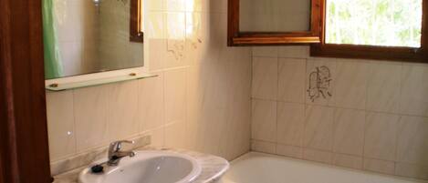 A bathroom with a white sink, a mirror, and a bathtub.