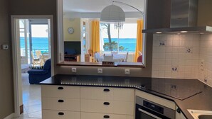 A modern kitchen with a large window, a built-in oven, and a dishwasher.