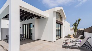 A modern outdoor patio with a pool table, lounge chairs, and a pergola. - Modern & bright, only a short walk into the town centre, A/C & heated pool (Playa Blanca)